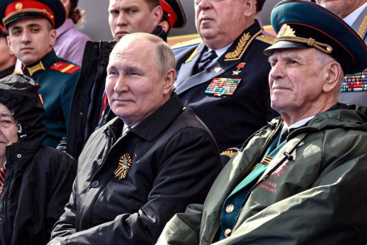 El presidente ruso, Vladímir Putin, sentado entre veteranos de la Segunda Guerra Mundial durante el desfile del Día de la Victoria, el 9 de mayo de 2022, en Moscú.