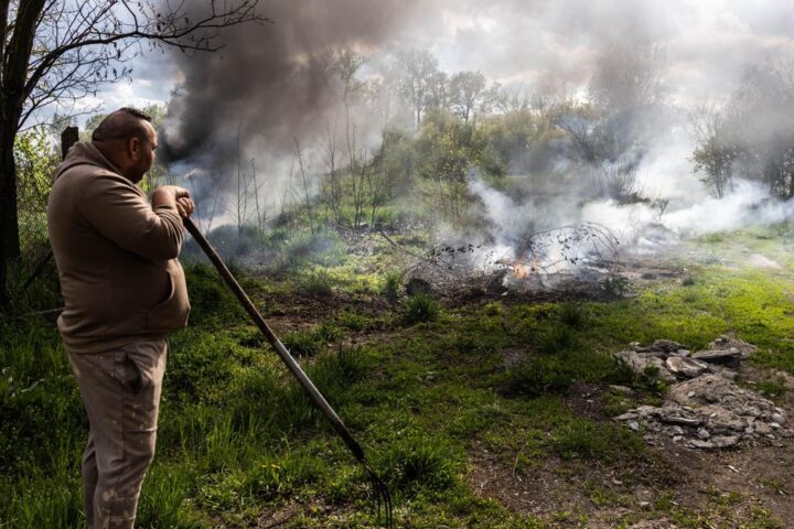 Bence observa el fuego frente a su hogar.