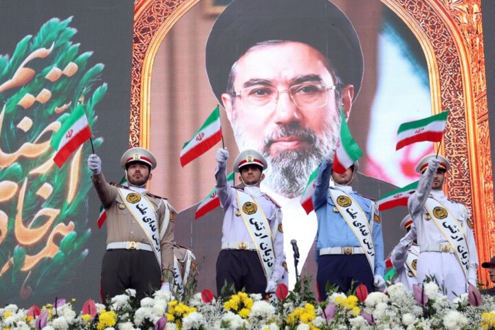 Miembros del ejército iraní ondean banderas nacionales frente a un cartel del líder supremo iraní, el ayatolá Mojtaba Jamenei, durante una manifestación en Teherán, Irán, el 29 de abril de 2026.