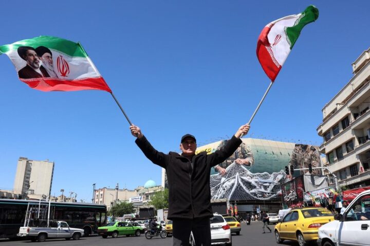 Un hombre ondea banderas iraníes en la plaza de Enghelab de Teherán, el 22 de abril de 2026.