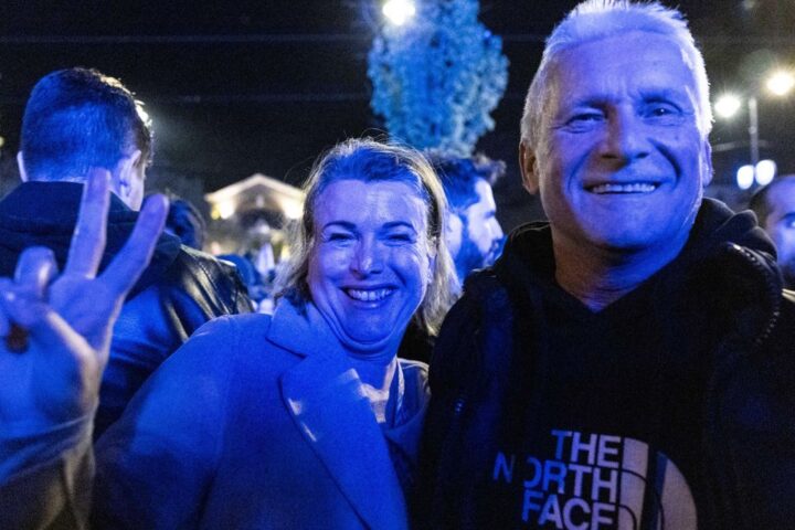 Una pareja hace el símbolo de la victoria en la plaza donde Péter Magyar anunció su victoria.