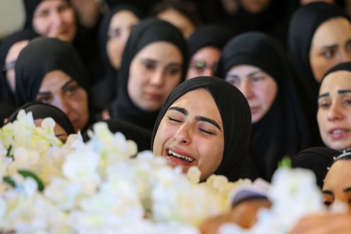 Una mujer llora ante el féretro de la periodista asesinada por Israel Amal Khalil