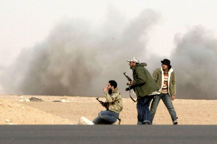 Combatientes rebeldes responden al fuego durante un bombardeo de soldados leales al líder libio Muamar Gadafi en una batalla cerca de Ras Lanuf, el 4 de marzo de 2011.