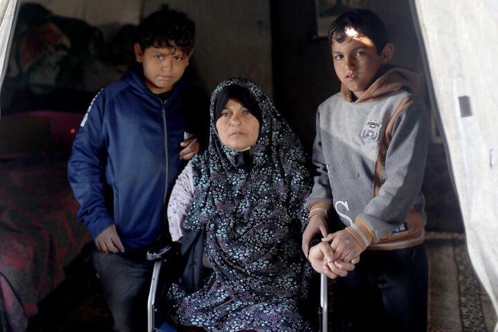 Maryam Abdullah con dos de sus hijos en el campamento de desplazados donde viven en Gaza, en marzo de 2026.