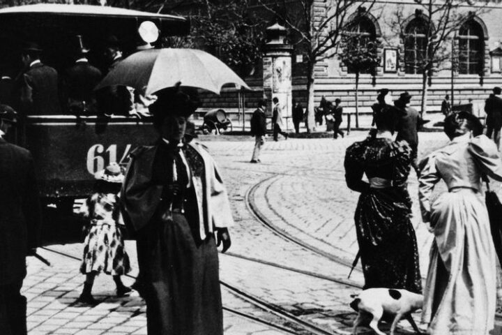 Un grupo de mujeres pasea por una calle de Viena al paso de un tranvía en 1892.