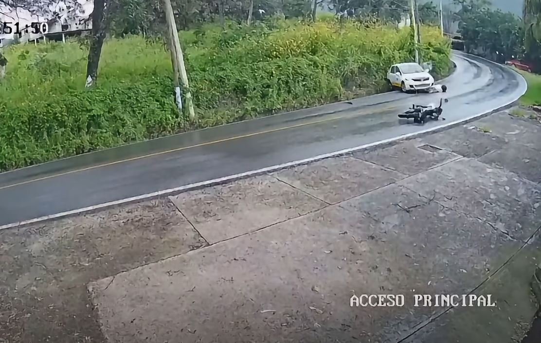 Impactante carambola en carretera mojada: vehículo pierde el control y motociclista colisiona contra el mismo